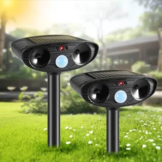 dual outdoor ultrasonic deterrent devices with solar panels and motion sensors in sunny garden - electronic pest control units for repelling wildlife