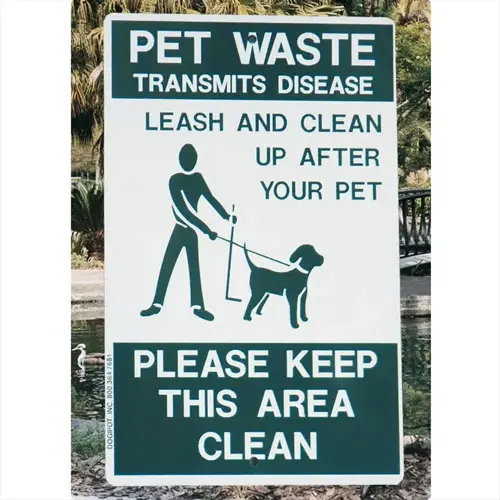 green and white 'pet waste' sign showing silhouetted person holding dog on leash with cleanup text. dog leash sign