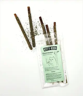 kitty kush chewie goodies bag with catnip silvervine chew sticks scattered around. encourages playful chewing behavior for cats
